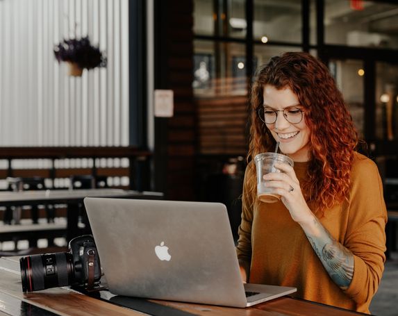 woman casual coffee mac laptop orange top