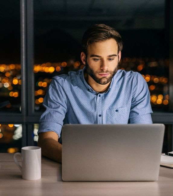 man laptop night time office
