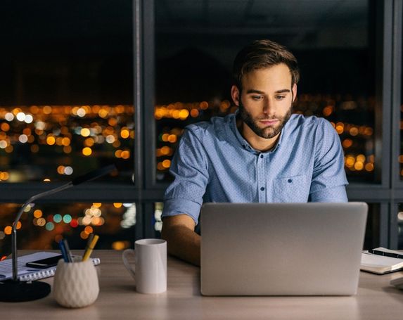 man laptop night time office